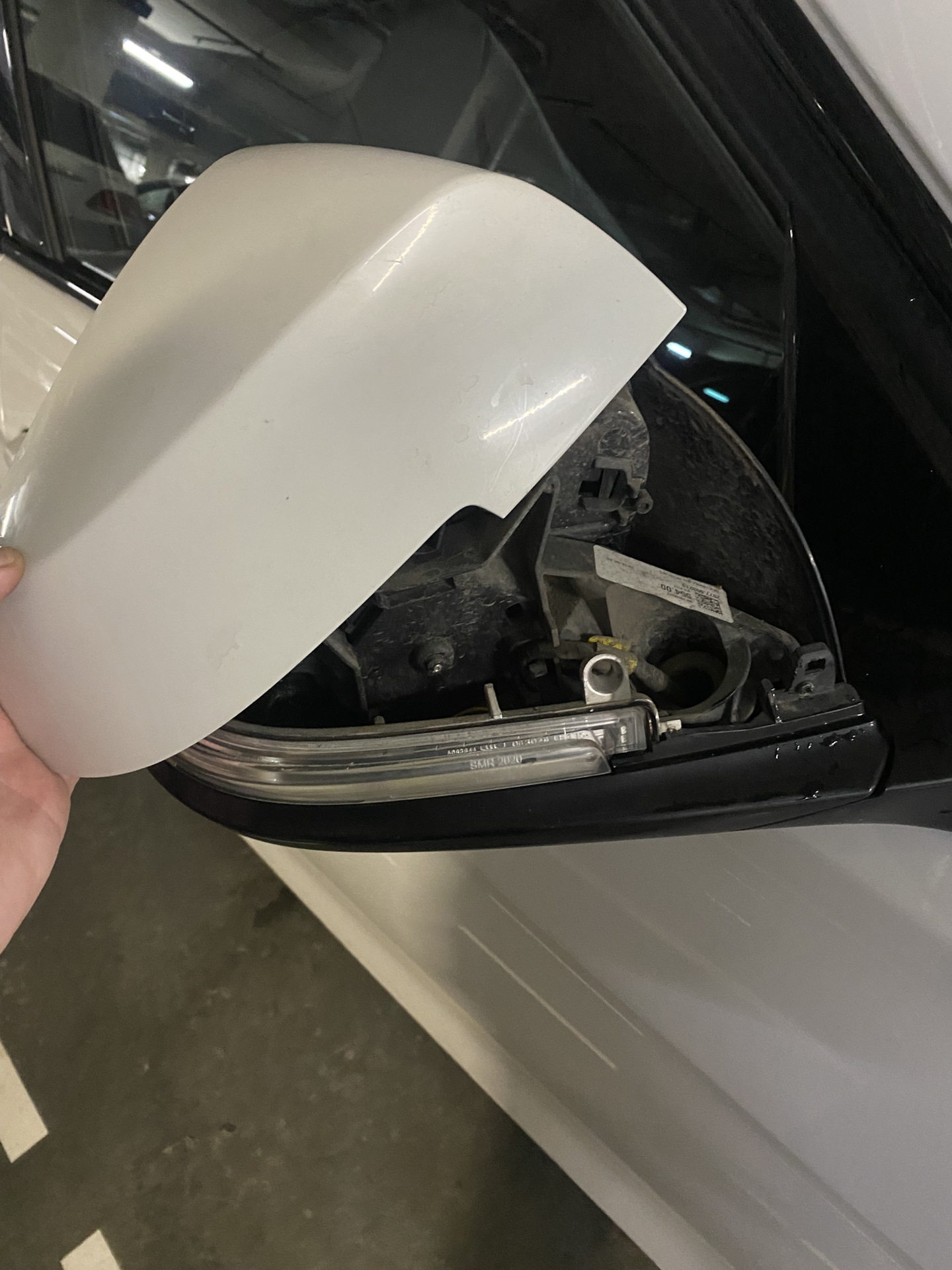 BMW side mirror cover partly removed to expose the housing