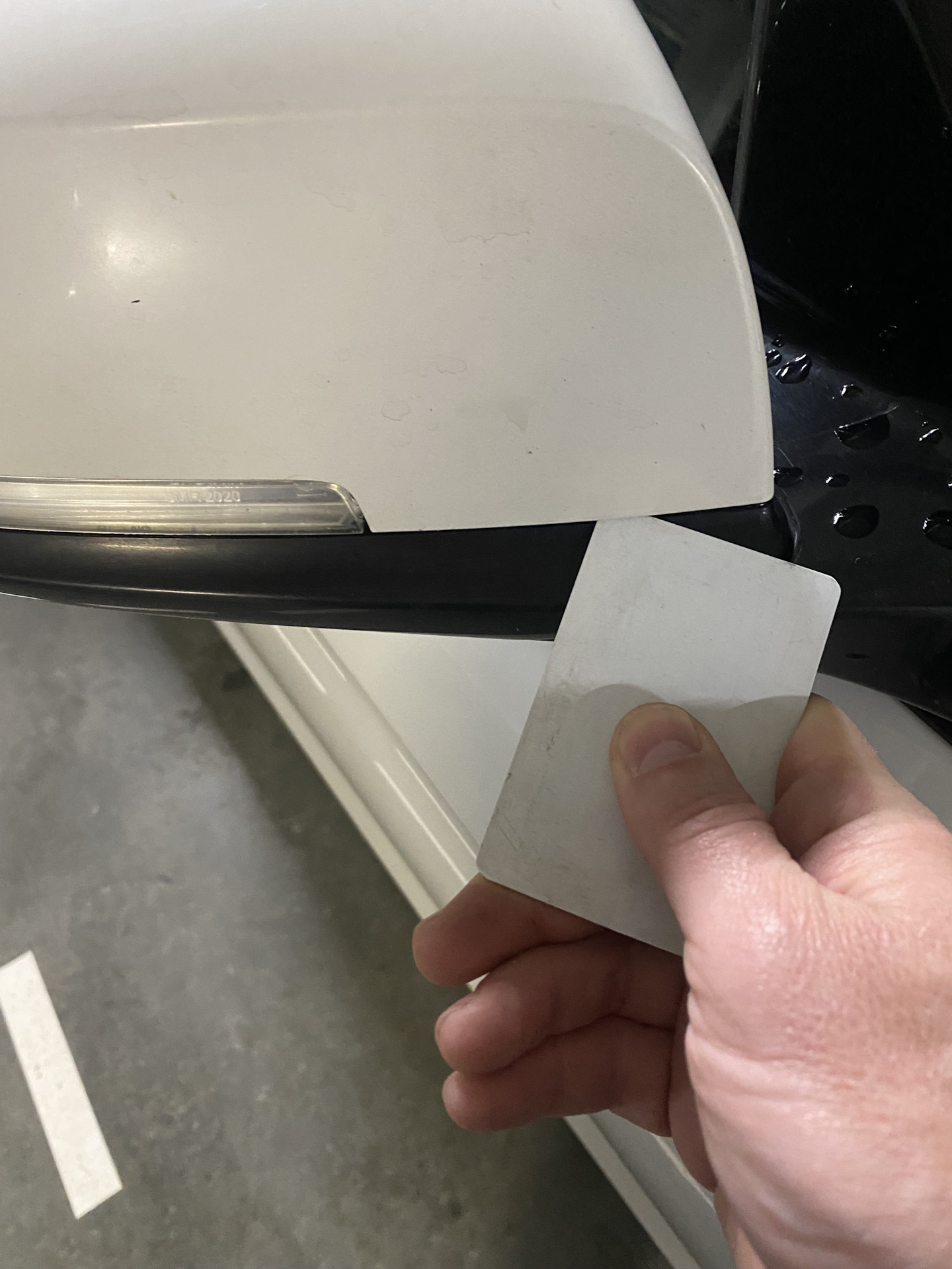 Plastic card releasing the clips of a BMW side mirror cover